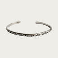 Silver stainless steel cuff bracelet with engraved symbols inspired by Brazilian culture.