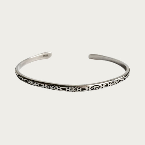 Silver stainless steel cuff bracelet with engraved symbols inspired by Brazilian culture.