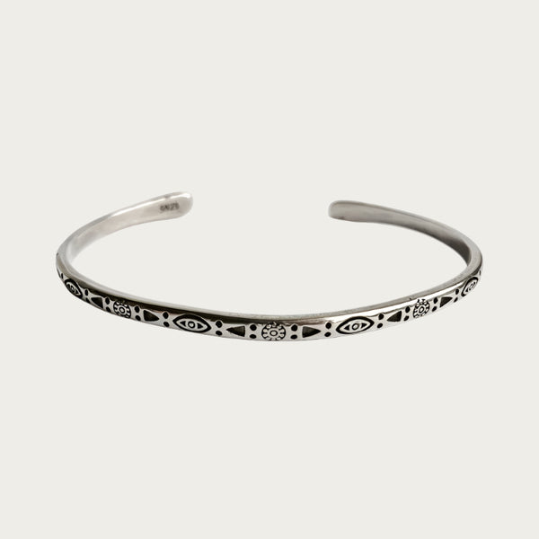 Silver stainless steel cuff bracelet with engraved symbols inspired by Brazilian culture.