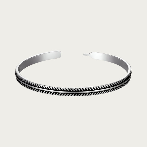 Silver cuff bracelet with feather-inspired engravings and Brazilian summer style.