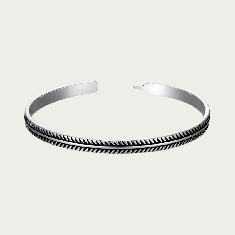 Silver cuff bracelet with feather-inspired engravings and Brazilian summer style.