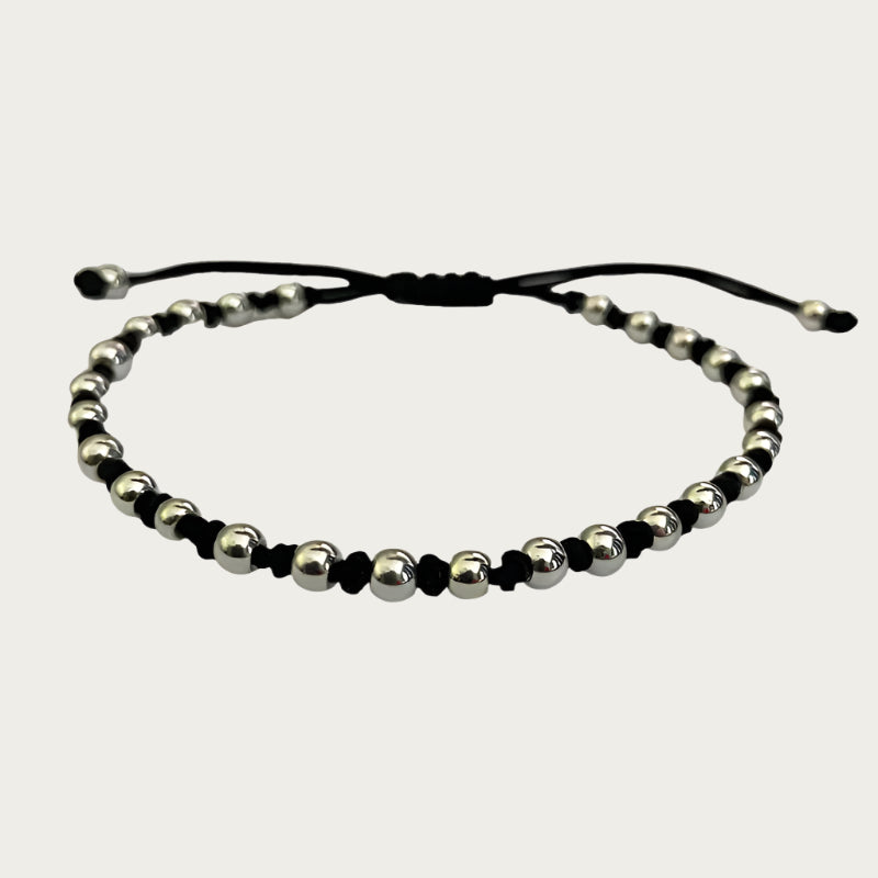 Beaded bracelet with silver-plated beads and black cord inspired by Brazilian design.